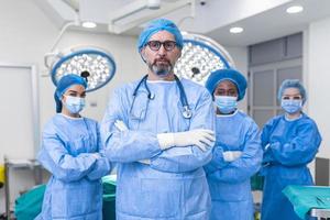 gruppo di medico chirurghi indossare ospedale scrub nel operativo Teatro. ritratto di riuscito medico lavoratori nel chirurgico uniforme nel operazione Teatro, pronto per Il prossimo operazione. foto