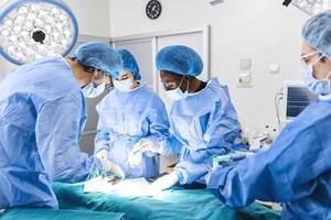 chirurgico squadra l'esecuzione chirurgia nel moderno operazione teatro, squadra di medici concentrandosi su un' paziente durante un' chirurgia, squadra di medici Lavorando insieme durante un' chirurgia nel operativo camera,