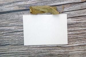 a5 carta saluto carta modello con asciutto le foglie su di legno sfondo foto