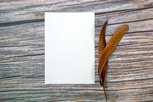 a5 carta saluto carta modello con asciutto le foglie su di legno sfondo foto