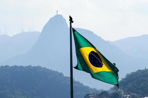 rio de janeiro, rj, brasile - aprile 27, 2022 - brasiliano bandiera onde con corcovado collina e Cristo il Redentore statua a sfondo - duca de caxias forte, leme Quartiere foto