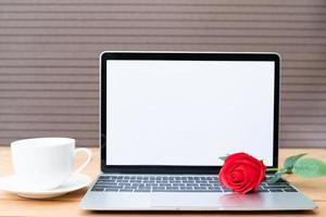 rosso rosa e caffè tazza con il computer portatile modello su legna foto