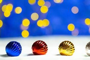 blu, rosso, giallo Natale giocattoli su il neve. indietro sfocato sfondo con luci. nuovo anno bokeh. copia spazio foto