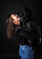 una ragazza tiene in braccio un cane labrador retriever. foto