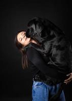 una ragazza tiene in braccio un cane labrador retriever. foto