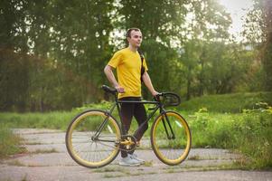 un giovane si è fermato a riposare con la sua bicicletta in un parco pubblico. foto