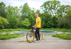 un giovane si è fermato a riposare con la sua bicicletta in un parco pubblico. foto