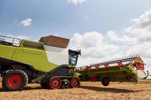 grande combinare mietitrici Lavorando nel agricolo campo a estate foto