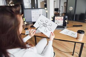 giovane adulto donna nel formale Abiti è in casa nel il ufficio foto