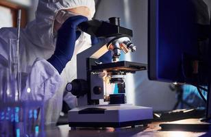 scienziato nel bianca protettivo uniforme lavori con coronavirus e sangue tubi nel laboratorio foto