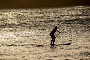 silhouette di un' persona paddling foto
