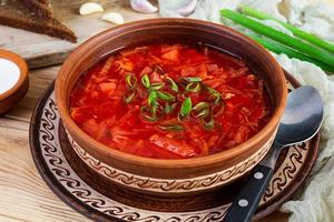 tradizionale ucraino borscht con verde cipolla e acida crema. delizioso barbabietola la minestra nel ciotola con segale pane foto