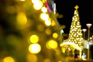 avvicinamento sfocato e bokeh di Natale luci su cespuglio e su messa a fuoco foto