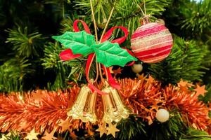 Natale d'oro campane e rosa cristallo palla con Natale guarnizioni decorato su pino albero sfondo. foto