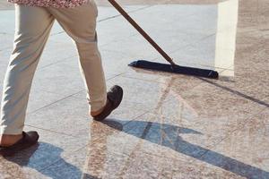 addetto alle pulizie con un' Mocio pulizia marmo pavimento all'aperto. pulizia servizio foto