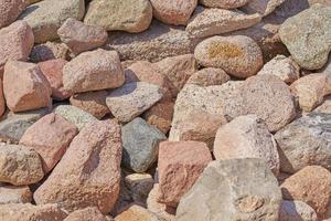 mucchio di grande rocce massi. sfondo di il Marrone pietre foto