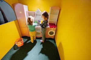 Due sorelle giocando a interno bambini cucina terreno di gioco. foto