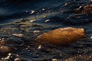 baltico mare costa con ciottoli e ghiaccio a tramonto foto