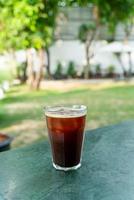 bicchiere di caffè americano ghiacciato sul tavolo foto