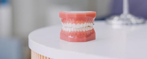 stomatologia concetto, parziale ritratto di ragazza con forte bianca denti guardare a telecamera e sorridente, dita vicino viso. avvicinamento di giovane donna a dal dentista, studio, in casa foto