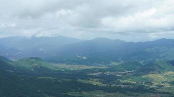 il raccolta giallo riso campo Visualizza collocato nel il valle tra il montagne con il nuvoloso cielo come sfondo foto