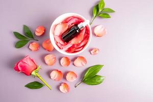 cosmetico bottiglia con facciale pelle cura prodotti. essenziale olio di rosa petali. siero basato su il estrazione di rosa petali. facciale pelle cura. foto