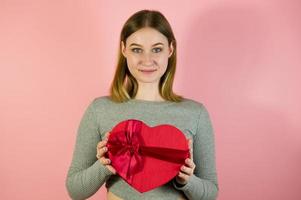 avvicinamento studio ritratto di giovane femmina Tenere cuore sagomato regalo scatola. st san valentino giorno concetto foto