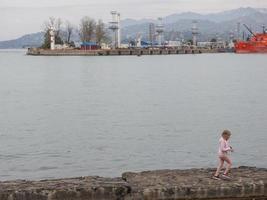 ragazza su il molo. mare costa. porta entro il città. foto