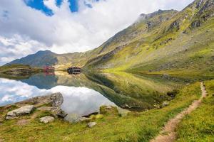 panoramico Visualizza di transilvania Alpi rispecchiato per alto altitudine balea lago nel Romania contro drammatico tempestoso nuvole foto