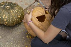 mani di vecchio maschio contadino solleva sopra il suo testa grande zucca su giardino letto raccolta concetto foto