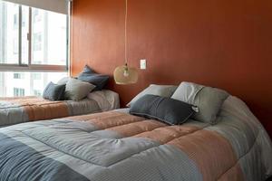 elegante interno di contemporaneo Camera da letto con confortevole arredamento. letto per Due con coperta foto