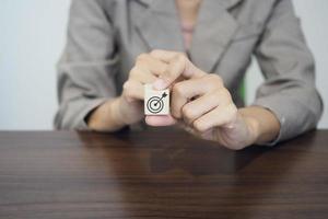 mano Tenere un' bersaglio quale è stampato su un' di legno bloccare. attività commerciale obiettivi, successo e pianificazione concetto. foto