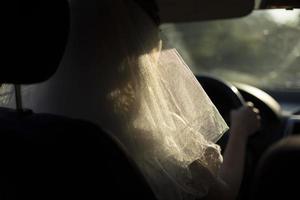 sposa è guida macchina. donna nel bianca velo nel trasporto. foto