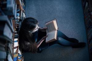 superiore Visualizza. nel gonna. femmina alunno è nel biblioteca quello pieno di libri. concezione di formazione scolastica foto