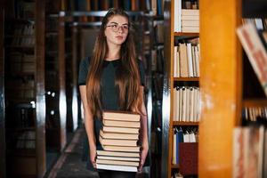 Là è un' lotto di informazione nel quello libri quello nel mani. femmina alunno è nel biblioteca. concezione di formazione scolastica foto