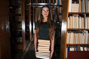 Là è un' lotto di informazione nel quello libri quello nel mani. femmina alunno è nel biblioteca. concezione di formazione scolastica foto