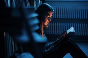 ottenere più intelligente ogni giorno. femmina alunno è nel biblioteca quello pieno di libri. concezione di formazione scolastica foto