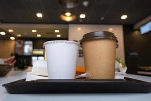 veloce cibo su un' vassoio nel un' ristorante. francese patatine fritte, un' bicchiere con un' frappè, caffè foto