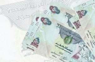 500 Emirati Arabi Uniti dirham fatture bugie nel pila su sfondo di grande semi trasparente banconota. astratto presentazione di nazionale moneta foto