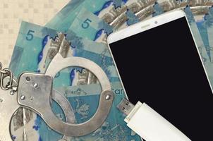 5 canadese dollari fatture e smartphone con polizia manette. concetto di gli hacker phishing attacchi, illegale truffa o il malware morbido distribuzione foto