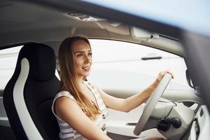 femmina autista dentro di moderno automobile. analisi marca nuovo auto foto