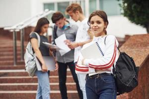 carino adolescente ragazza. gruppo di giovane studenti nel casuale Abiti vicino Università a giorno foto