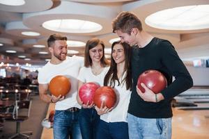 doppio appuntamento. i giovani amici allegri si divertono al bowling club durante i fine settimana foto