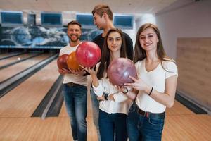 ragazzi che parlano tra loro. i giovani amici allegri si divertono al bowling club durante i fine settimana foto