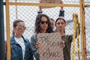 con nastro di avvertenza di colore giallo. gruppo di donne femministe protestano per i loro diritti all'aperto foto