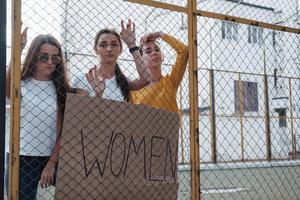 vicino al grande edificio bianco. gruppo di donne femministe protestano per i loro diritti all'aperto foto