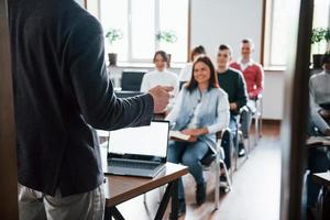 umore allegro. gruppo di persone alla conferenza di lavoro nella moderna classe durante il giorno foto