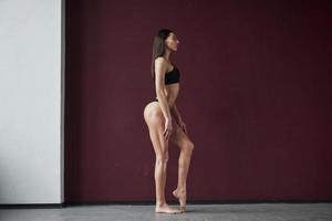 sexy posa. bella giovane donna con simpatico fitness corpo forma in piedi nel il camera foto