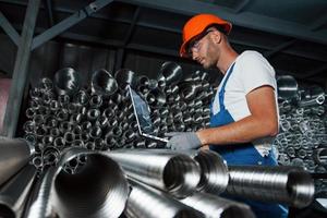 fatto con speciale acciaio. uomo nel uniforme lavori su il produzione. industriale moderno tecnologia foto