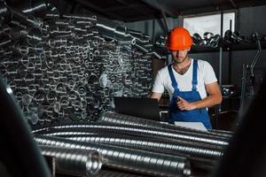 nel magazzino. uomo nel uniforme lavori su il produzione. industriale moderno tecnologia foto